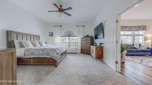 a bedroom with a bed a chandelier and a dresser