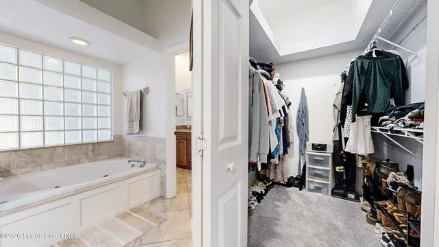 a view of walk in closet with clothes and shoes