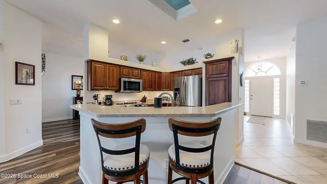 a kitchen with sink refrigerator dining table and chairs