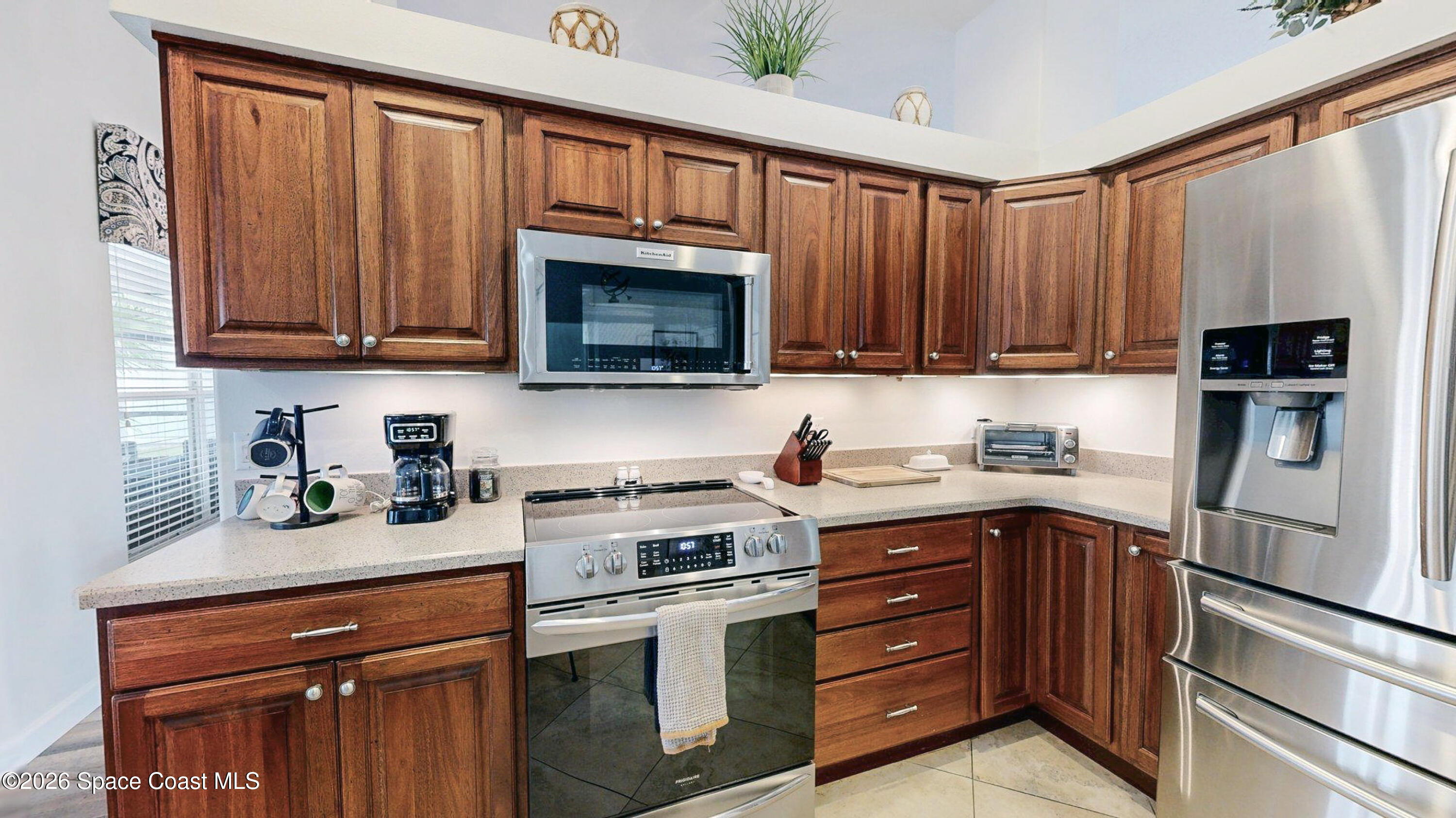 786 Conestee Drive Melbourne, FL 32904 - Photo 19 of 38 a kitchen with granite countertop wooden cabinets and stainless steel appliances
