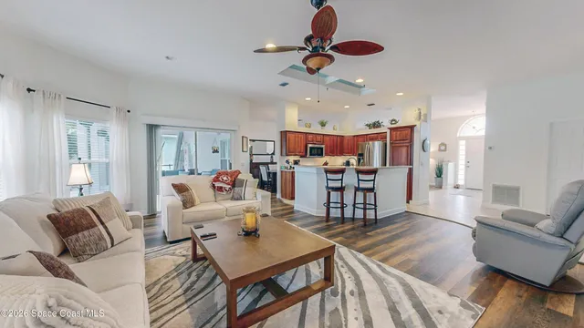 a living room with furniture kitchen view and a chandelier
