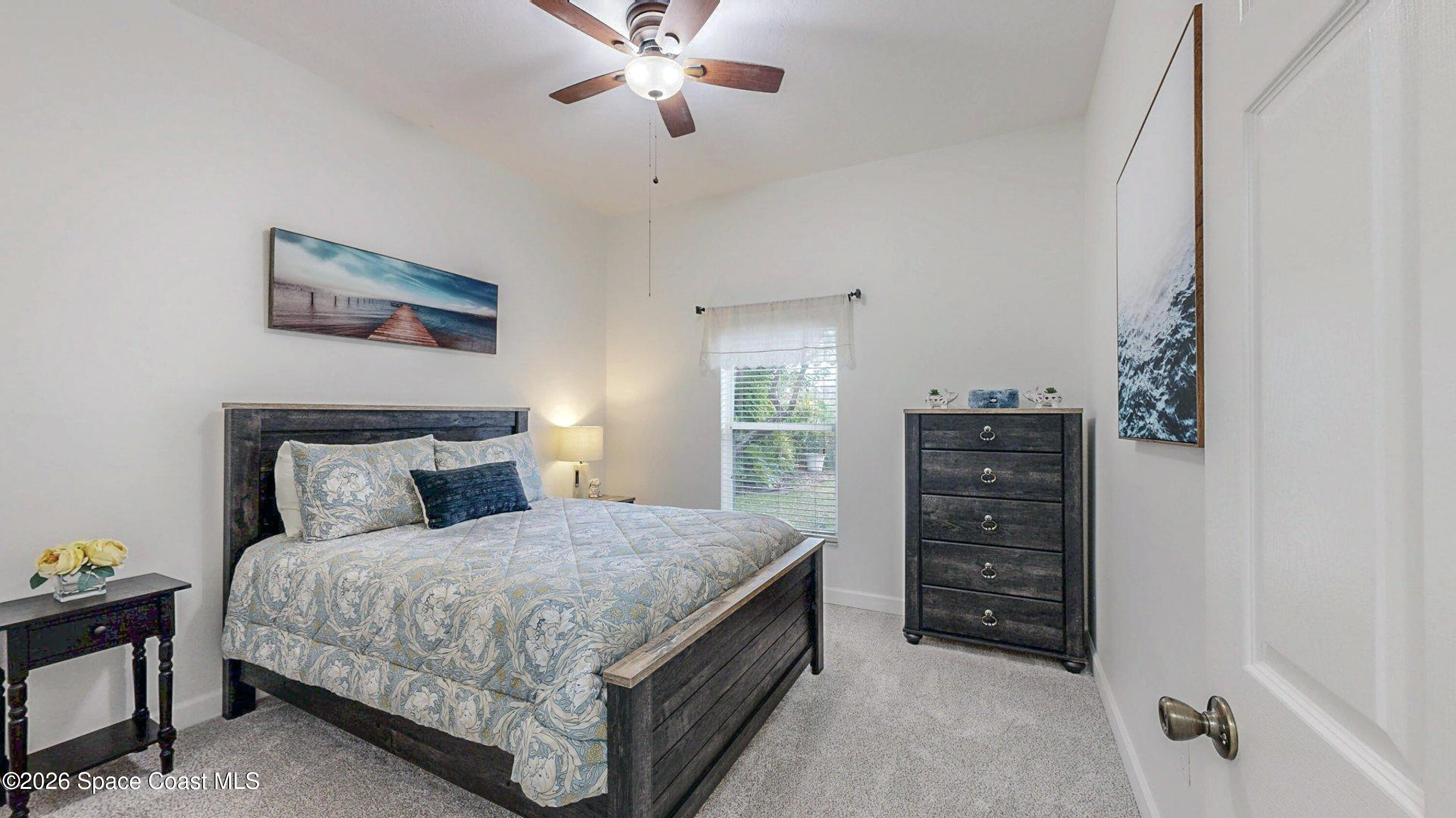 786 Conestee Drive Melbourne, FL 32904 - Photo 22 of 38 a bedroom with a bed and a chandelier