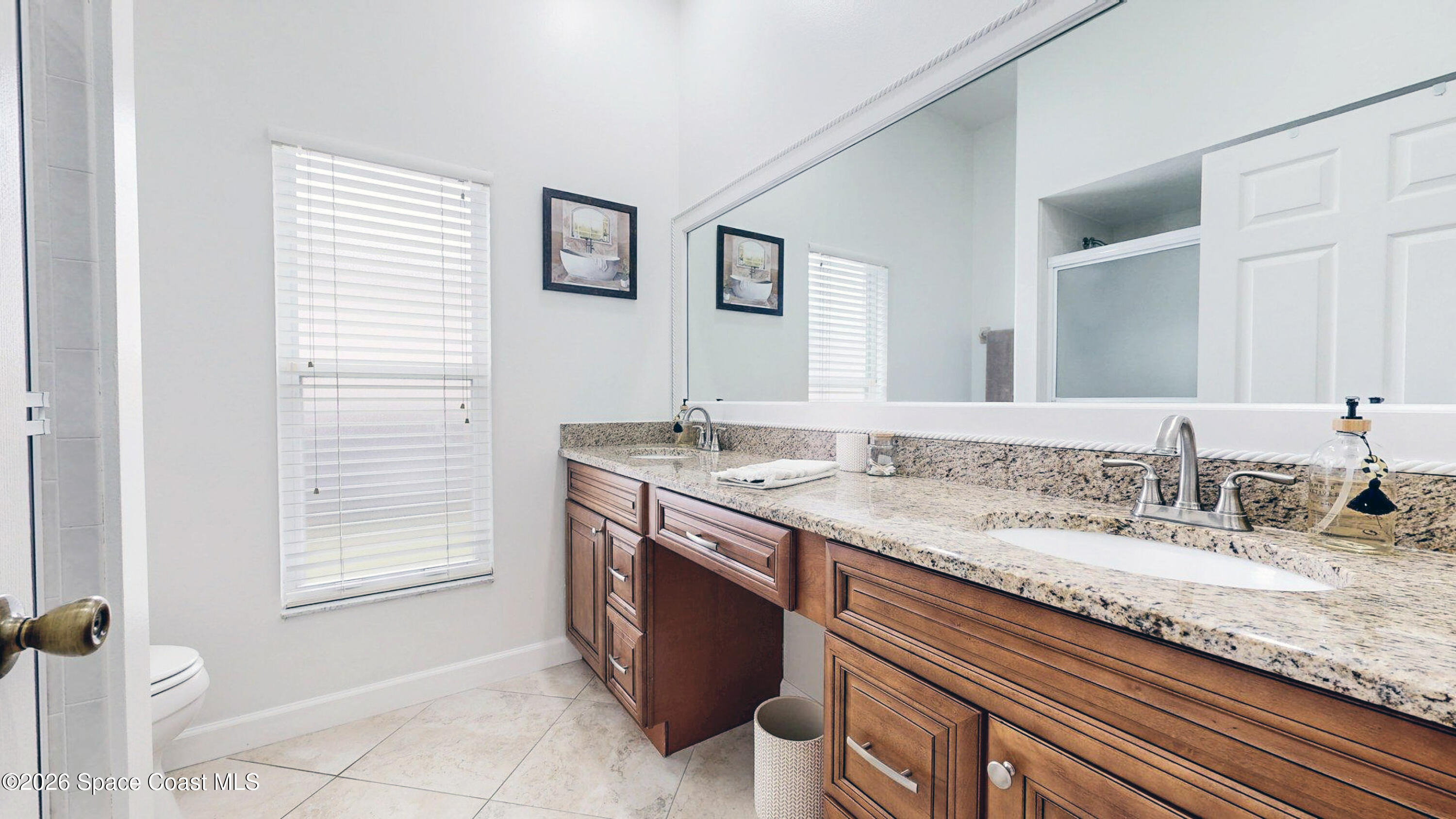 786 Conestee Drive Melbourne, FL 32904 - Photo 23 of 38 a bathroom with a granite countertop sink and a mirror