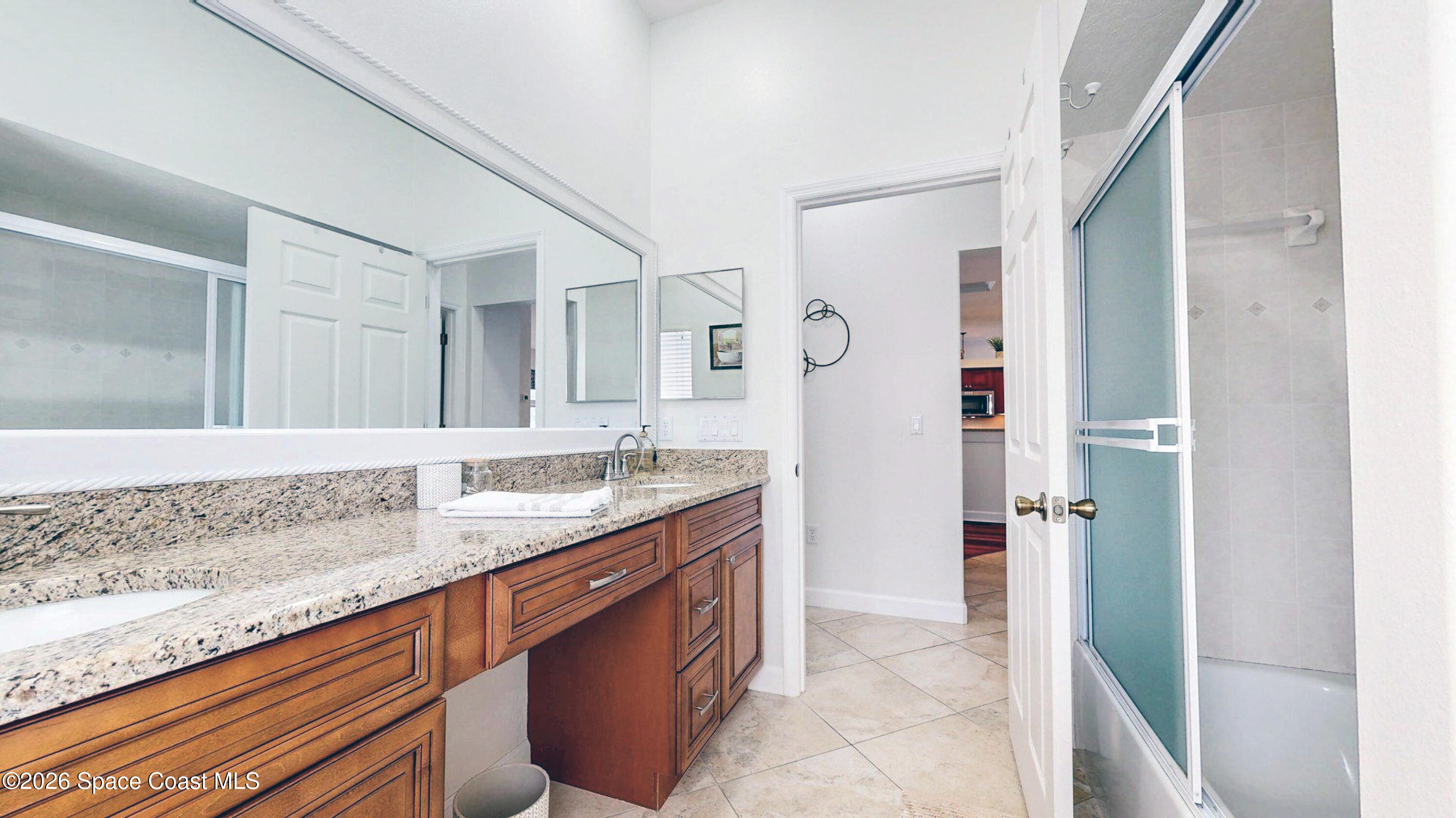 786 Conestee Drive Melbourne, FL 32904 - Photo 24 of 38 a bathroom with a granite countertop sink a mirror and a shower