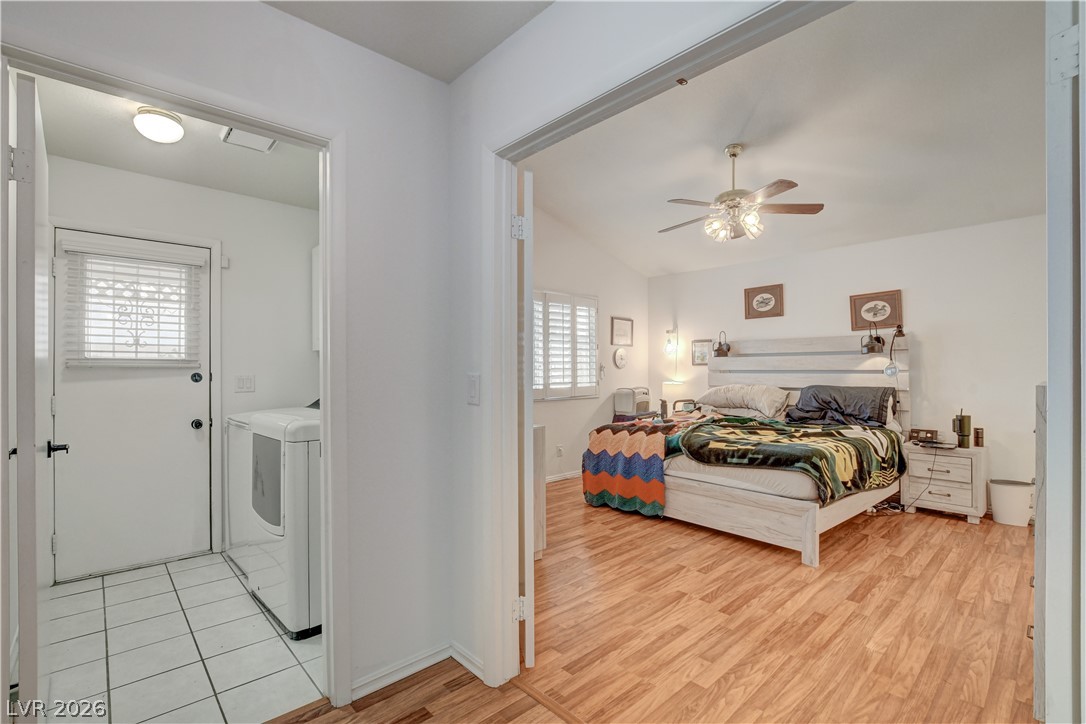 337 Washoe Way Henderson, NV 89074 - Photo 12 of 20 Bedroom featuring light wood finished floors, separate washer and dryer, a ceiling fan, ensuite bathroom, and vaulted ceiling
