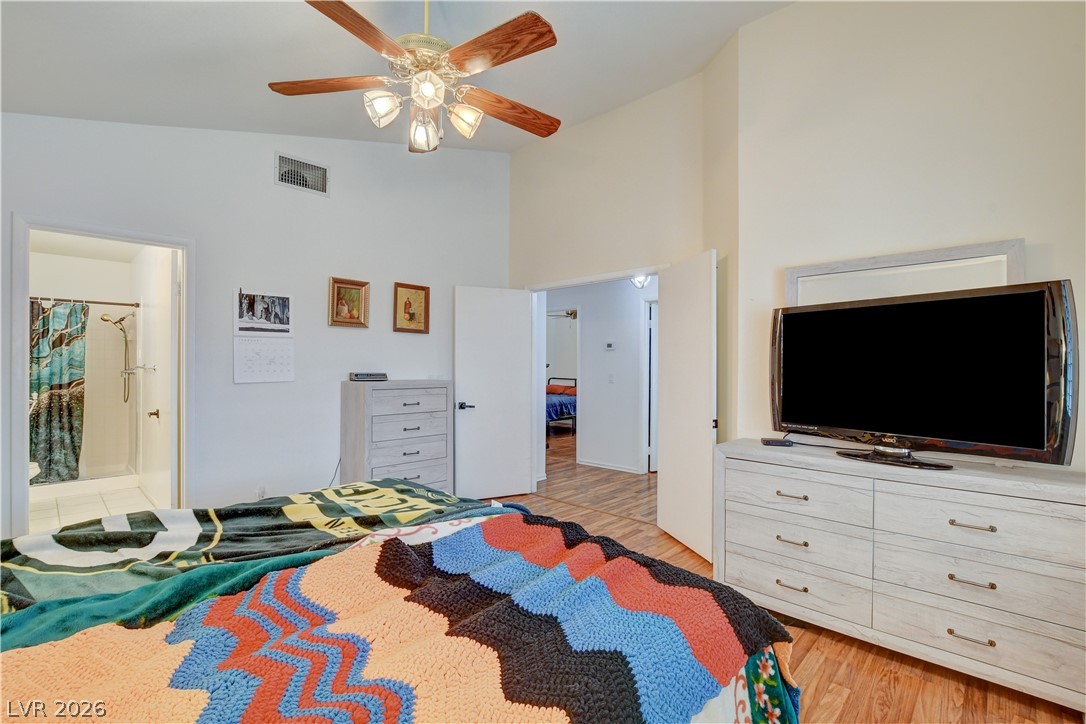 337 Washoe Way Henderson, NV 89074 - Photo 13 of 20 Bedroom featuring light wood-style flooring, connected bathroom, lofted ceiling, and ceiling fan