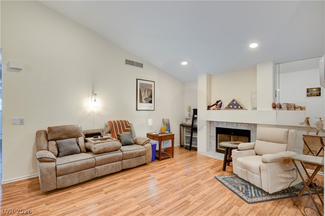 337 Washoe Way Henderson, NV 89074 - Photo 3 of 20 Living area featuring vaulted ceiling, light wood finished floors, a fireplace, and recessed lighting