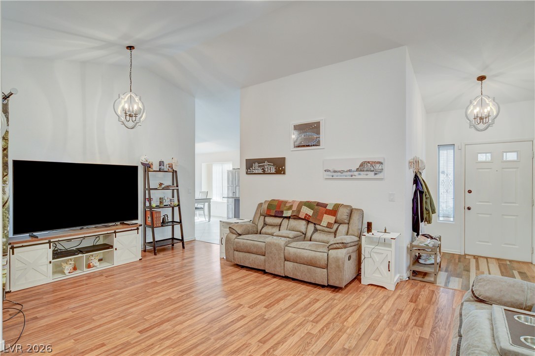 337 Washoe Way Henderson, NV 89074 - Photo 4 of 20 Living room featuring suspended lighting, lofted ceiling, and light wood-style flooring