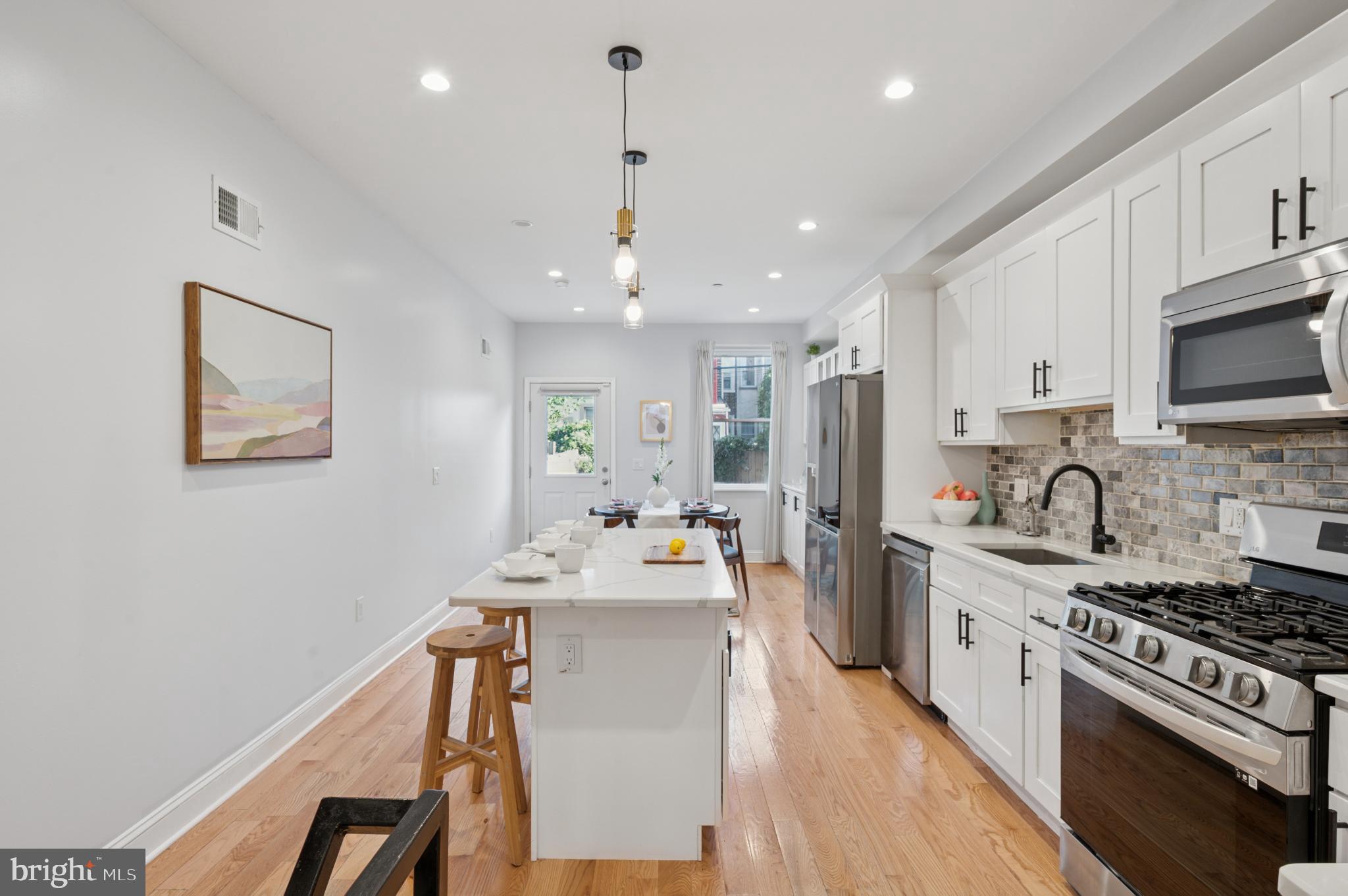 3263 Chatham Street Philadelphia, PA 19134 - Photo 6 of 46 a kitchen with stainless steel appliances a stove a sink a refrigerator cabinets and dining table