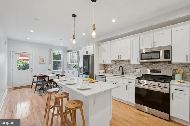 a kitchen that has a lot of cabinets a sink and appliances