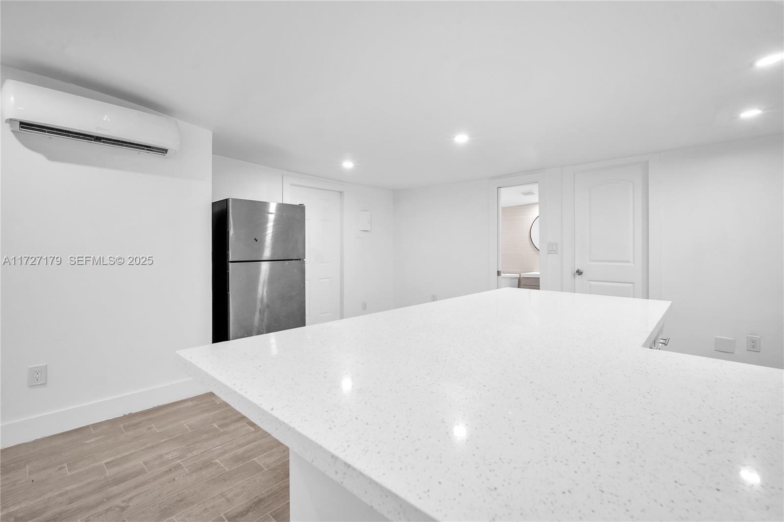 2372 Northwest 34th Street Miami, FL 33142 - Photo 11 of 50 a large white kitchen with refrigerator stove and wooden floor