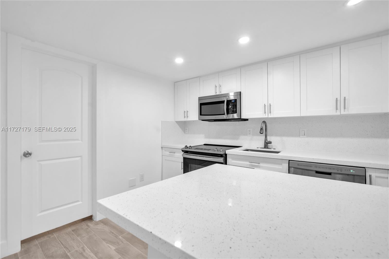 2372 Northwest 34th Street Miami, FL 33142 - Photo 12 of 50 a kitchen with sink a microwave and refrigerator