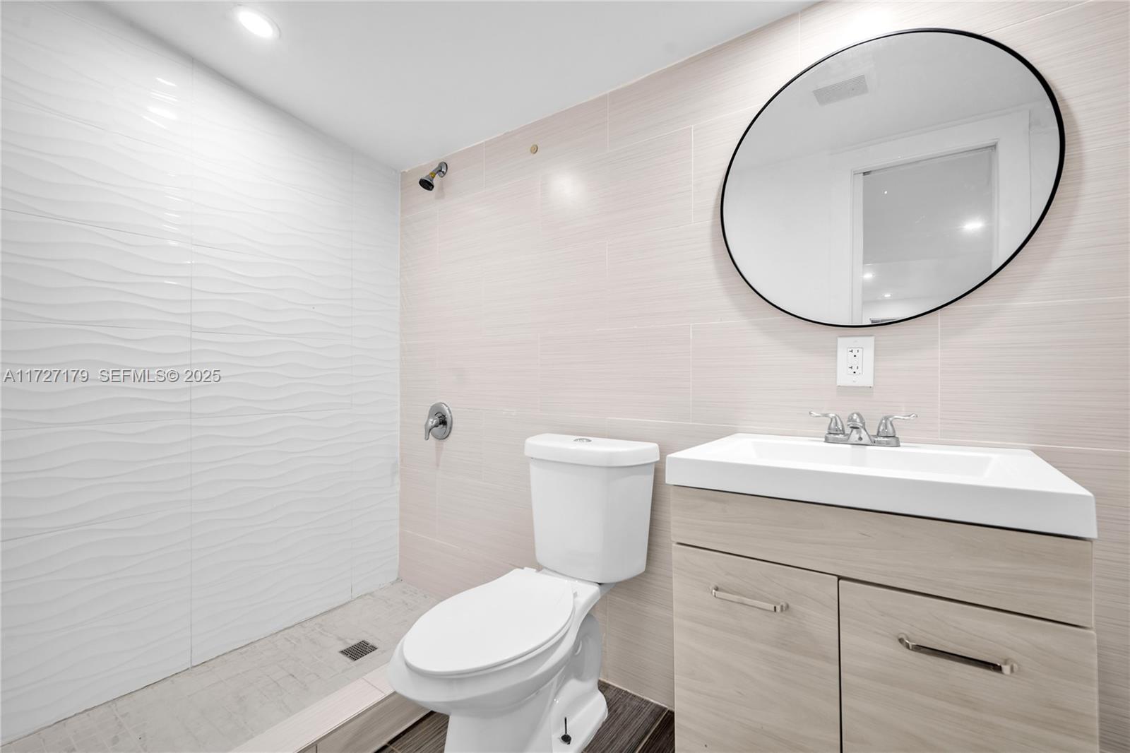 2372 Northwest 34th Street Miami, FL 33142 - Photo 17 of 50 a bathroom with a toilet a sink and a mirror