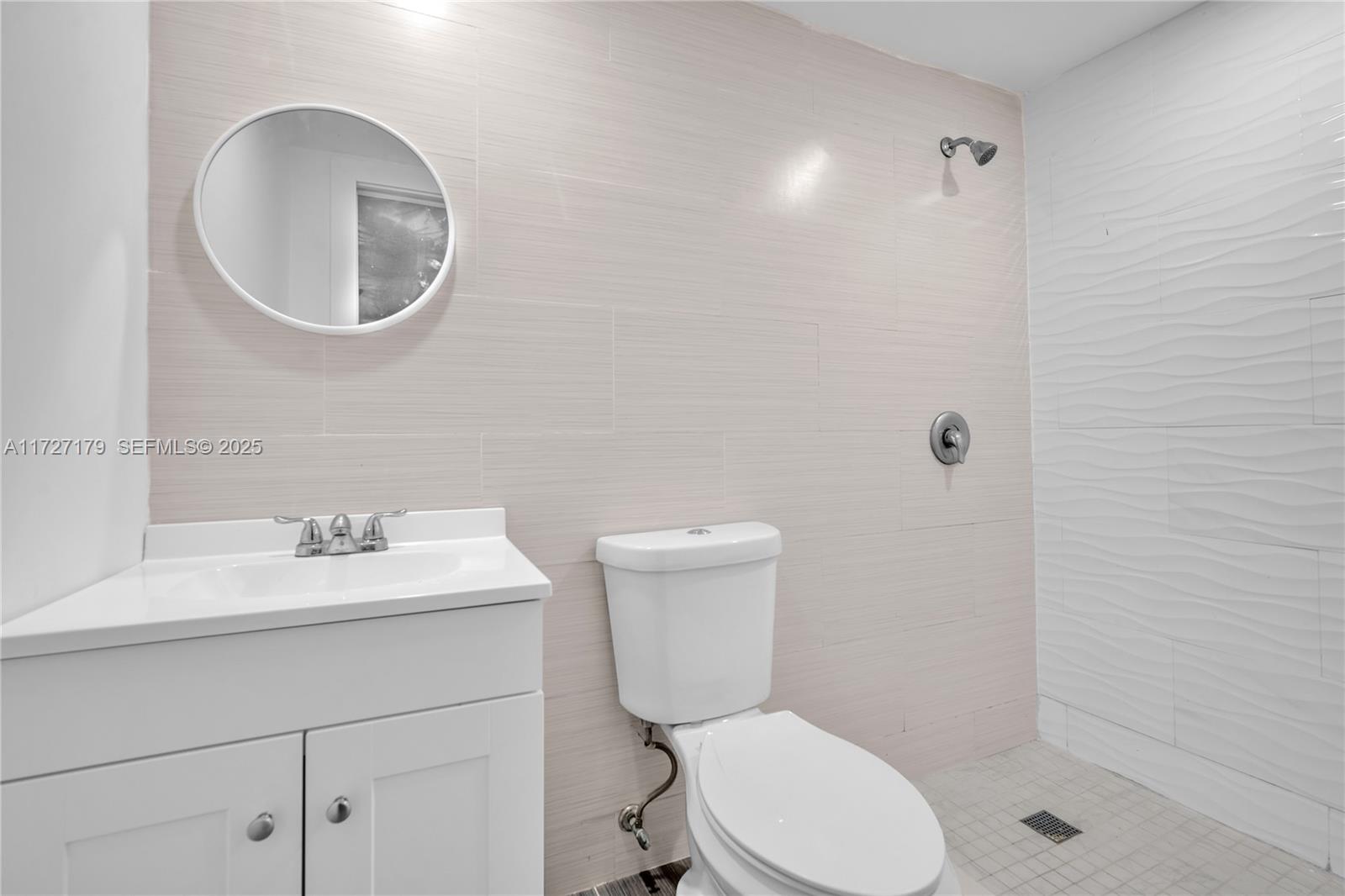 2372 Northwest 34th Street Miami, FL 33142 - Photo 18 of 50 a bathroom with a toilet sink vanity and mirror
