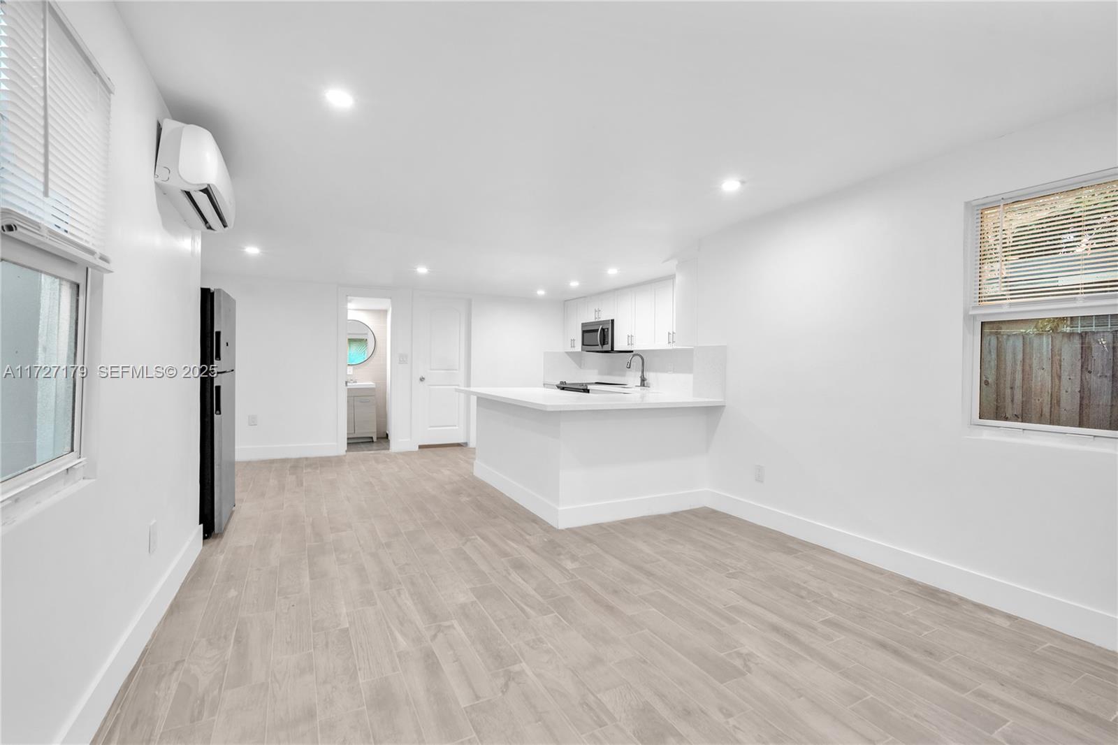 2372 Northwest 34th Street Miami, FL 33142 - Photo 9 of 50 a view of kitchen and white cabinets with wooden floor