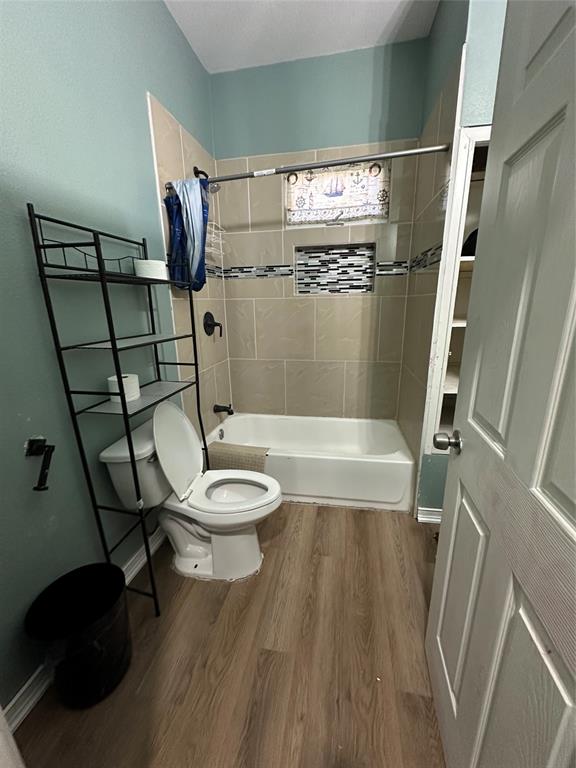 1824 Lyle Avenue Waco, TX 76708 - Photo 10 of 13 Bathroom with dark wood-style floors and bathing tub / shower combination