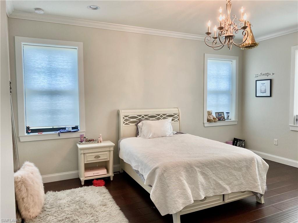 Undisclosed Address Naples, FL 34109 - Photo 26 of 33 a bedroom with a bed chandelier and a window