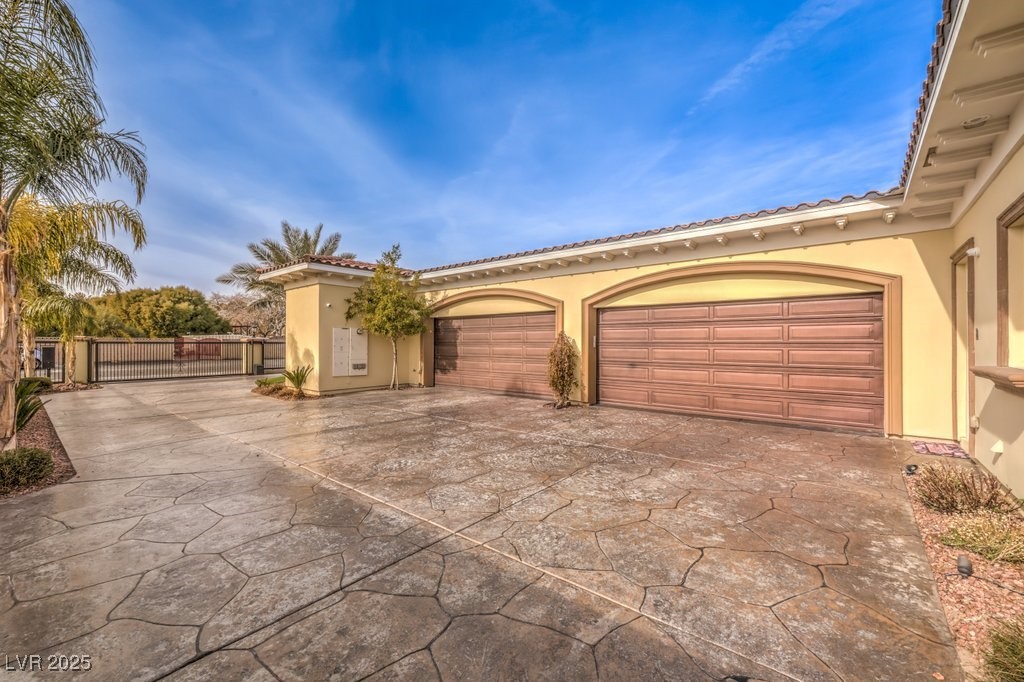 2780 El Camino Road Las Vegas, NV 89146 - Photo 22 of 90 View of front of property featuring a tiled roof, driveway, a gate, an attached garage, and stucco siding