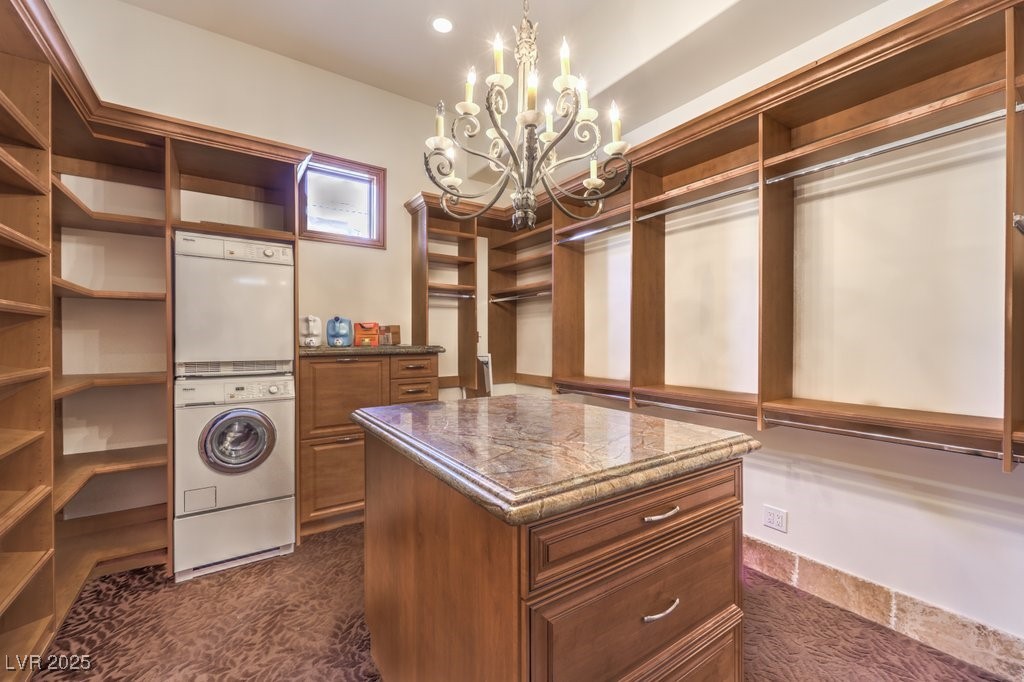 2780 El Camino Road Las Vegas, NV 89146 - Photo 46 of 90 Walk in closet with an inviting chandelier, stacked washer / dryer, and dark carpet