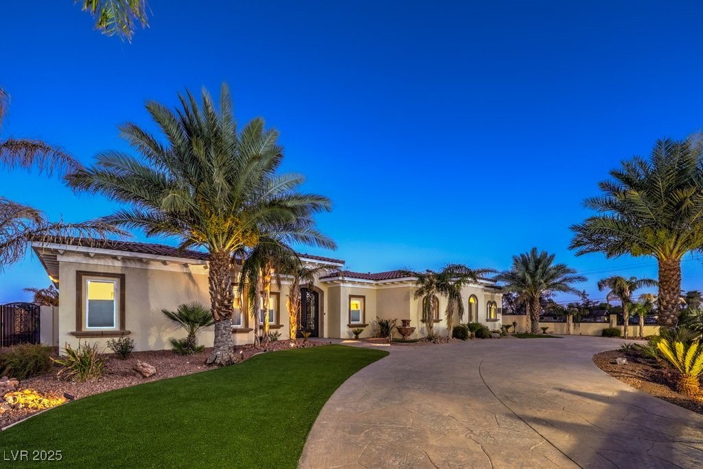 2780 El Camino Road Las Vegas, NV 89146 - Photo 5 of 90 Mediterranean / spanish home with curved driveway, a front lawn, stucco siding, and a tile roof
