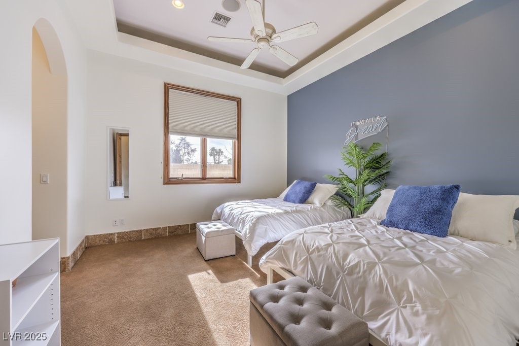 2780 El Camino Road Las Vegas, NV 89146 - Photo 52 of 90 Carpeted bedroom with visible vents, arched walkways, ceiling fan, and a tray ceiling