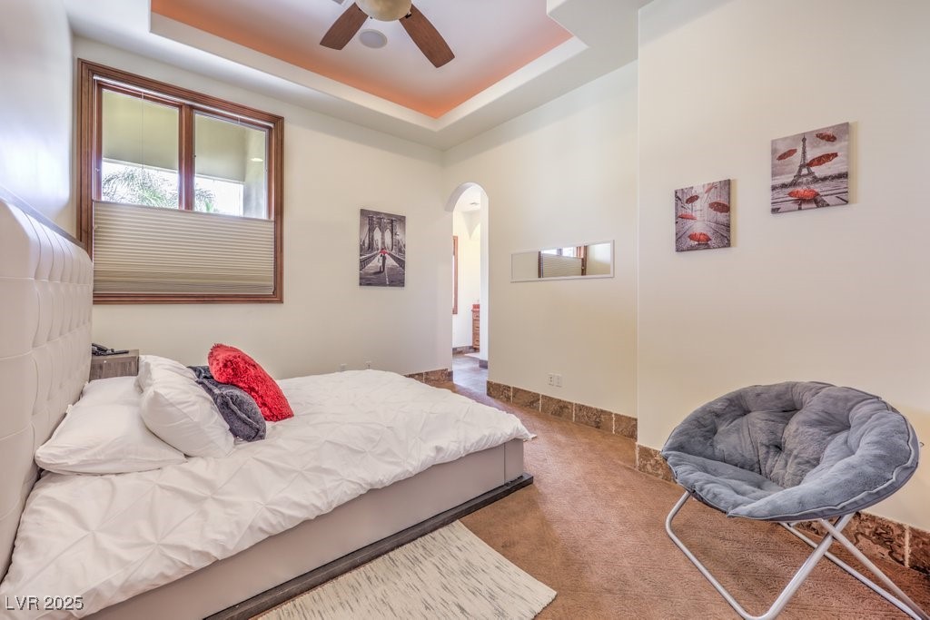 2780 El Camino Road Las Vegas, NV 89146 - Photo 54 of 90 Carpeted bedroom with arched walkways, a raised ceiling, and ceiling fan