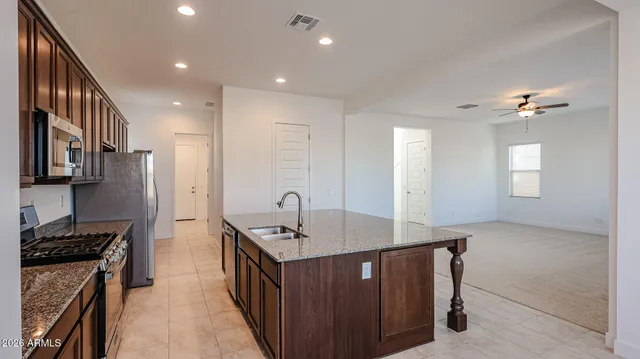 a kitchen with stainless steel appliances granite countertop a sink stove and refrigerator