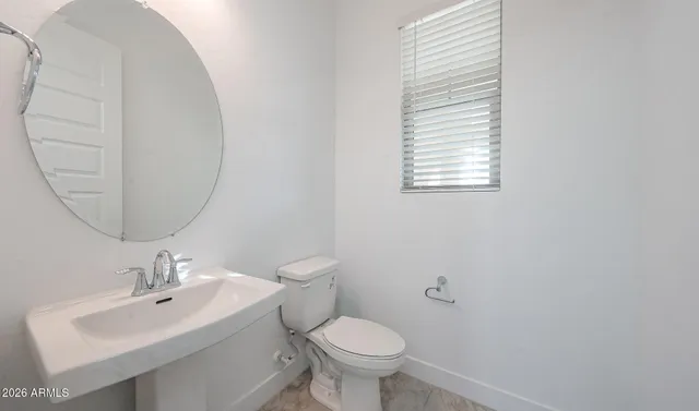 a bathroom with a toilet a sink and a mirror