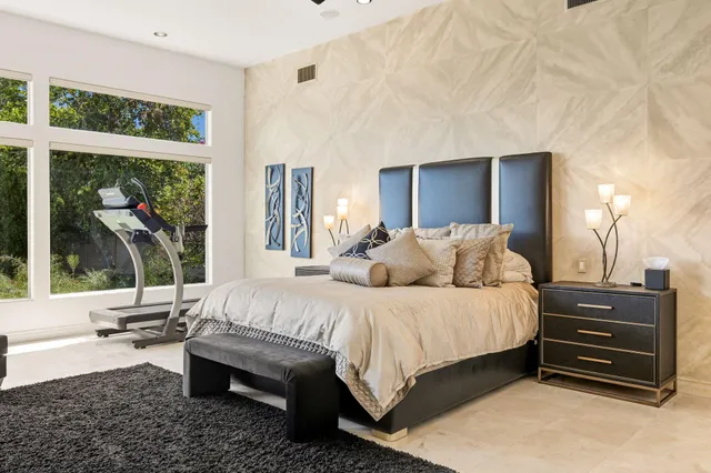 a view of a patio with couches table and chairs with plants and wooden fence