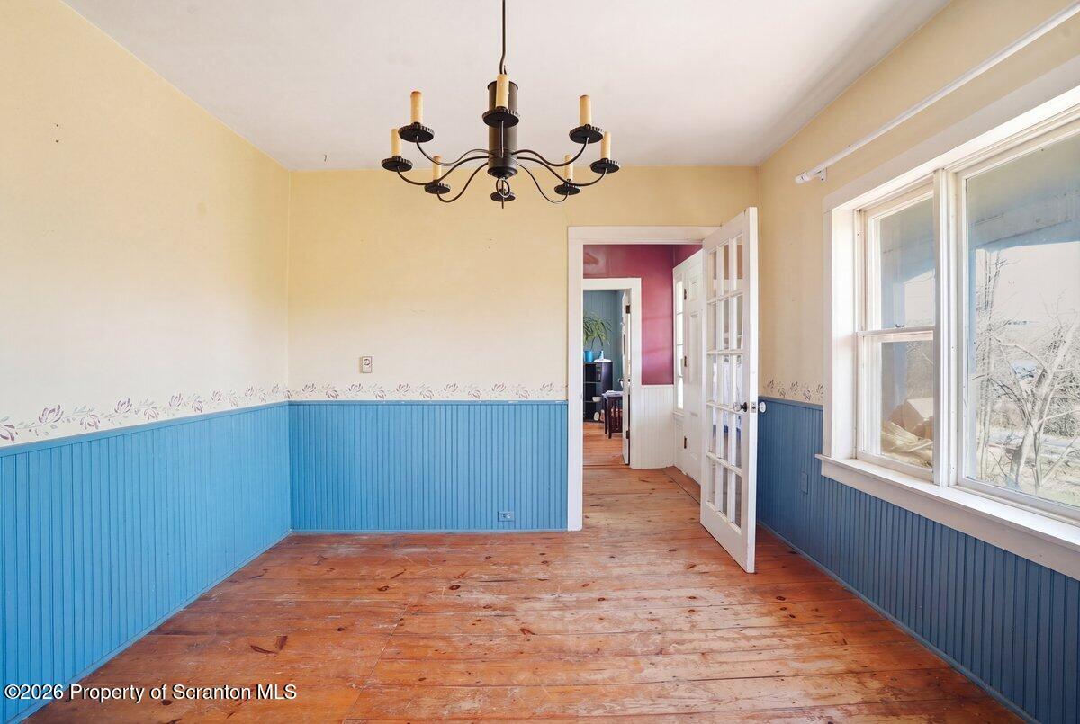 519 Sutton Road New Milford, PA 18834 - Photo 13 of 80 a view of a room with wooden floor and chandelier