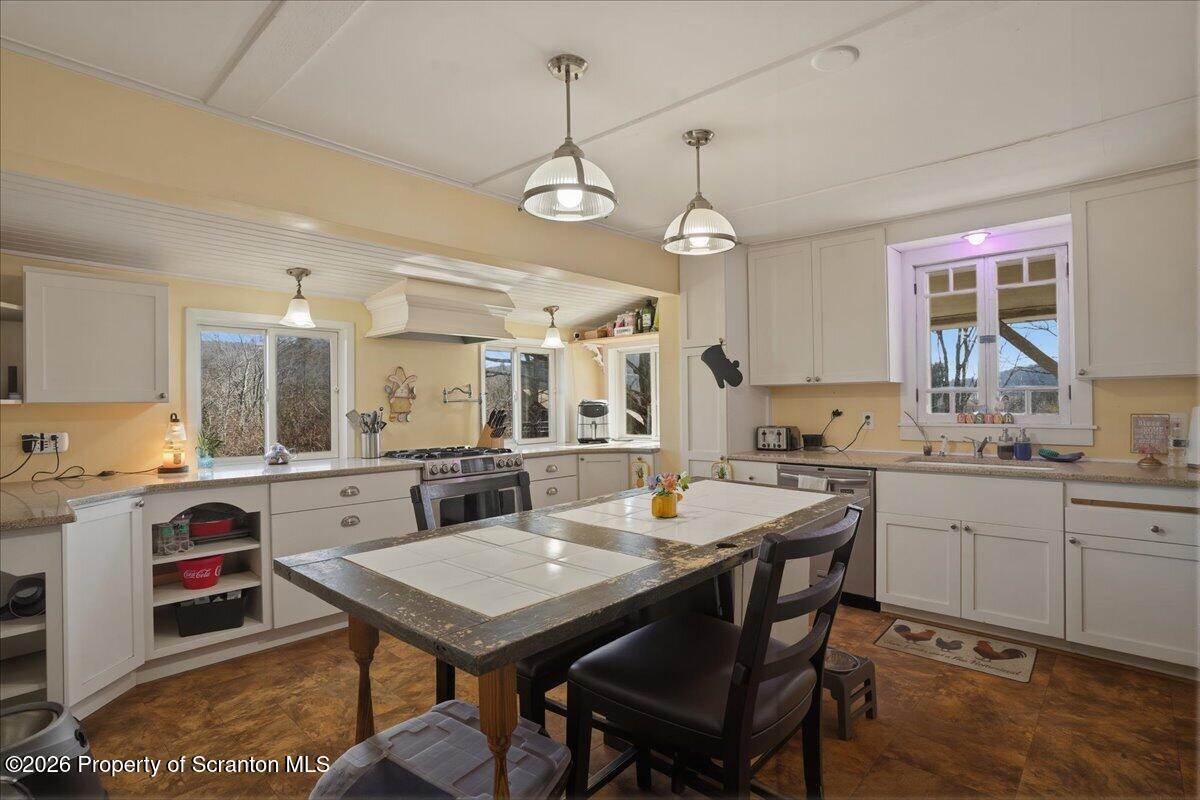 519 Sutton Road New Milford, PA 18834 - Photo 14 of 80 a kitchen with a stove a sink a dining table and chairs