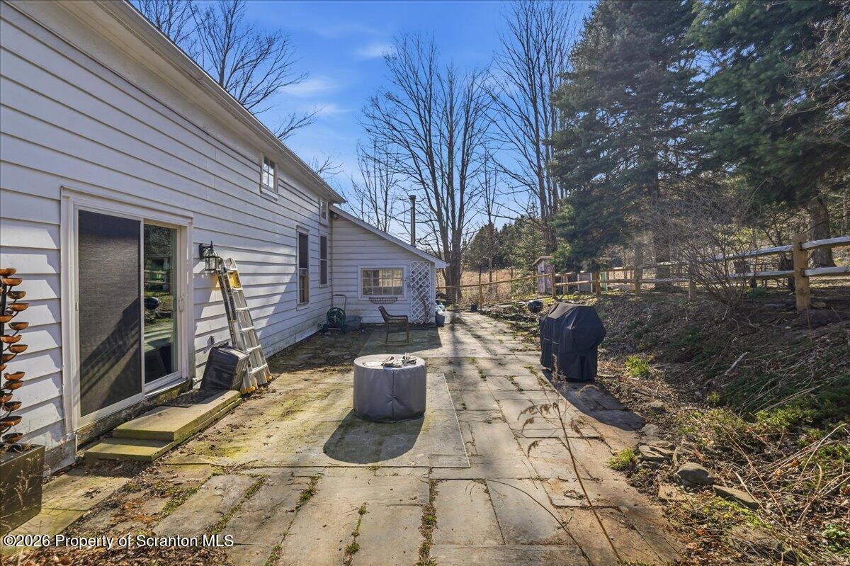 519 Sutton Road New Milford, PA 18834 - Photo 44 of 80 a view of a backyard with table and chairs and wooden fence
