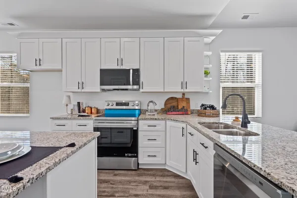 a view of kitchen with cabinets microwave and stove