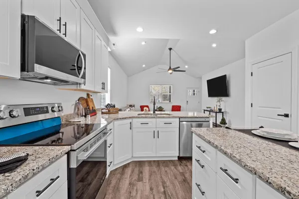 a kitchen with granite countertop a sink stove and cabinets