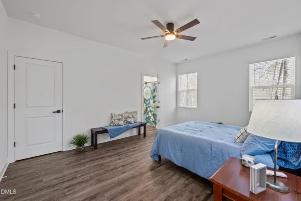 a view of empty room with wooden floor and fan
