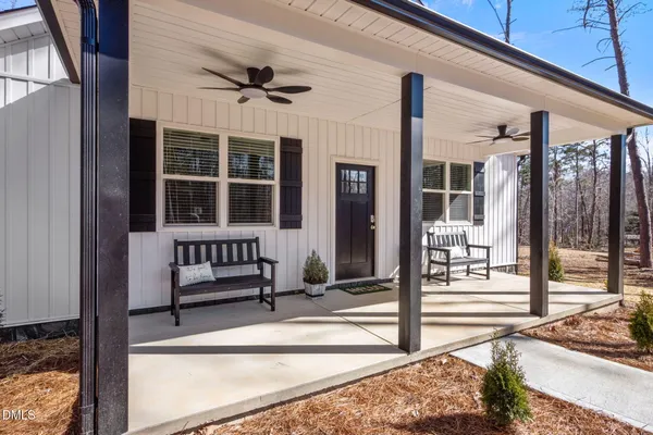 a porch with a bench next to a road
