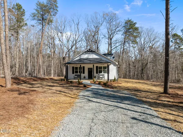 a front view of house with yard space and trees around