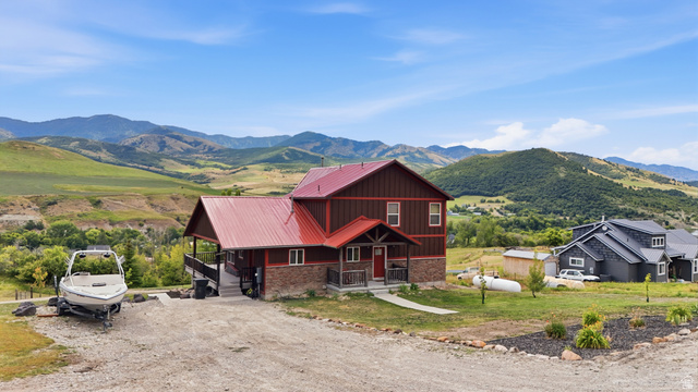 306 Spring Road Preston, ID 83263 - Photo 54 of 55 Two-story residence featuring a red metal roof and a stone and wood-paneled exterior