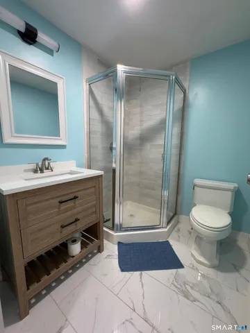 a bathroom with a toilet a sink and mirror