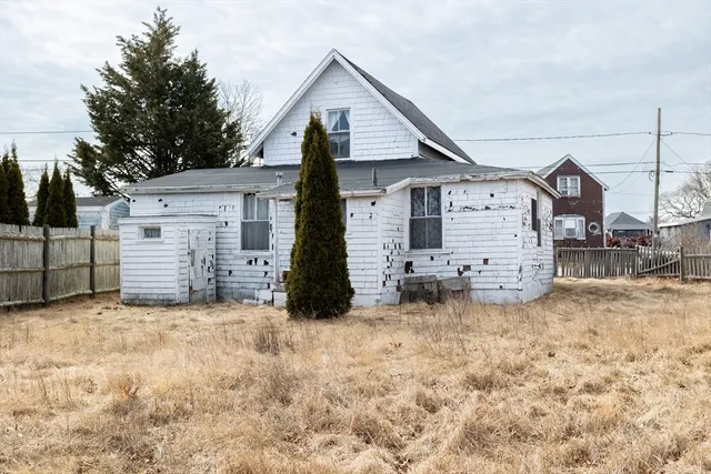 a view of a house with a large tree and a yard
