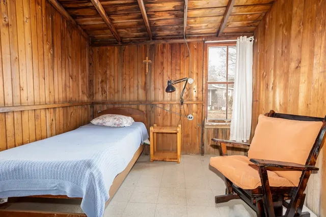 a bedroom with a bed and a dresser next to a window