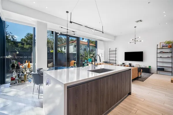 a large kitchen with kitchen island a sink and a large window