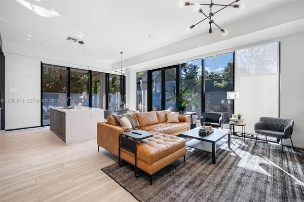 a living room with furniture and large windows