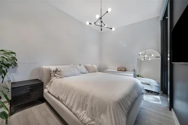 a bedroom with a bed and a chandelier