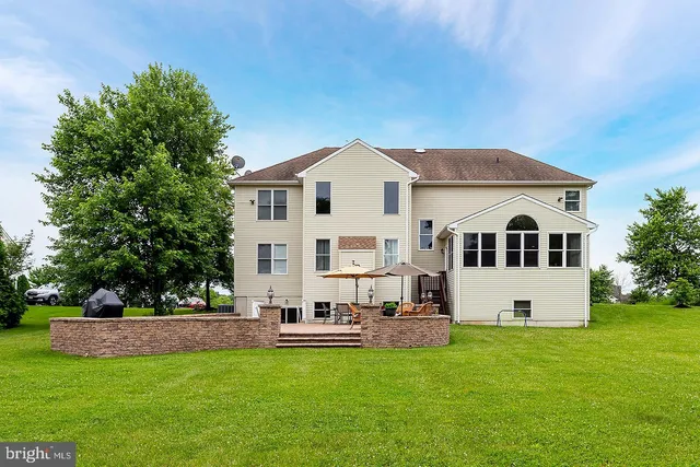 a front view of a house with a garden and trees