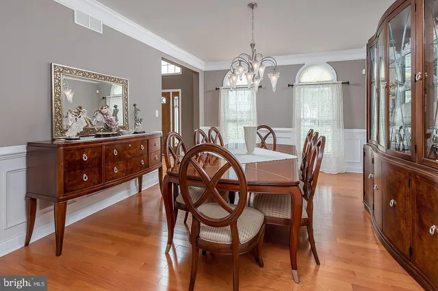 a view of a dining room with furniture a chandelier and wooden floor