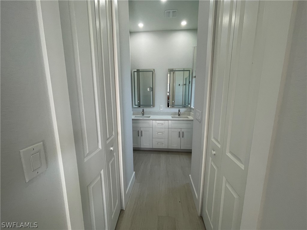 603 West 9th Street Lehigh Acres, FL 33972 - Photo 7 of 14 a en suite bathroom with a sink a mirror and a shower