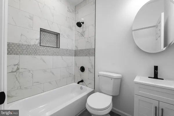 a bathroom with a toilet a sink a mirror and bathtub