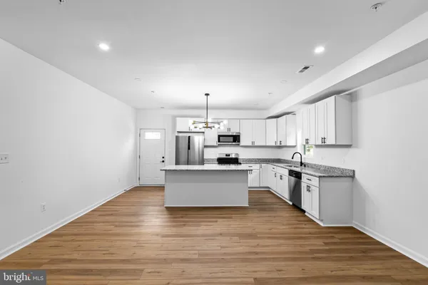 a kitchen with white cabinets counter top space and stainless steel appliances