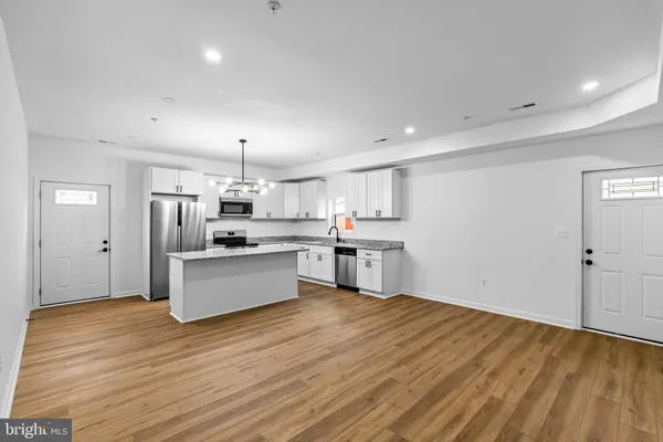 a large kitchen with kitchen island a sink stainless steel appliances and cabinets